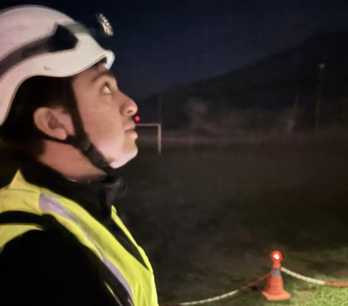 Piloto con casco y chaleco reflectante controla un vuelo nocturno